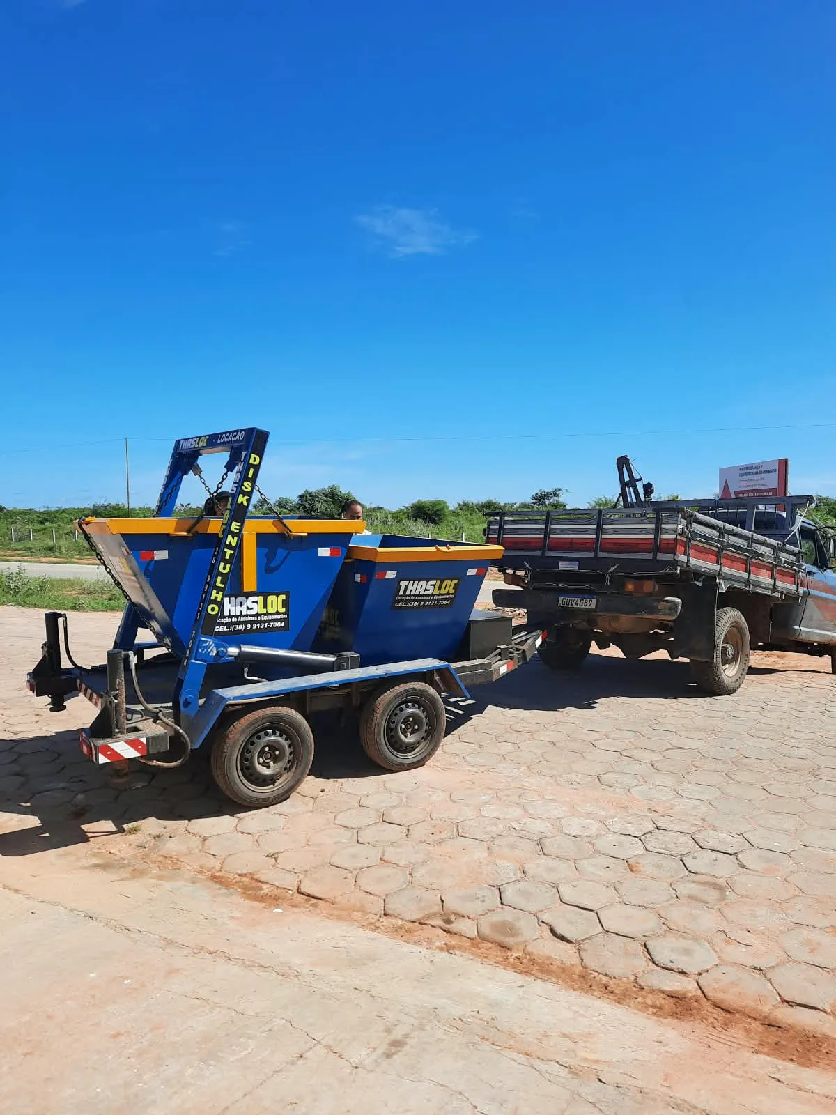 Caçamba de entulho da THASLOC sobre carreta, engatada na caminhonete para entrega